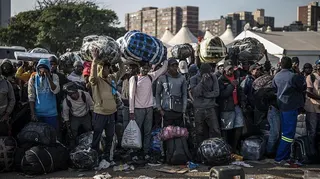 Migrants lining up near a bus to take them away