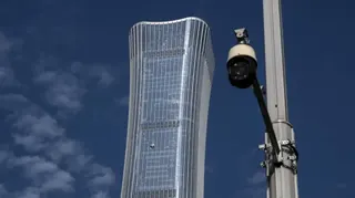 從地面眺望北京「中國尊」大樓高層，右側有一閉路電視鏡頭（監控攝像頭）（27/6/2026）
