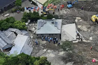 山口县平生町发生山体滑坡，一栋两层住宅的一楼被泥沙碎石掩埋。当地警察和救援人员随后抵达现场进行搜救工作。 （路透社）