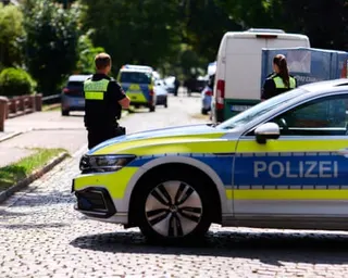 German police vehicles and officers patrol an area near a mass shooting in Stade