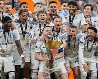 The Aston Villa captain John McGinn and his teammates celebrate with the Europa League trophy.