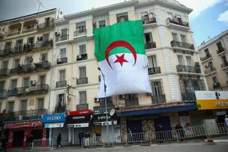 The national flag of Algeria hangs outside a building in Annaba, Algeria [Guglielmo Mangiapane/Reuters]