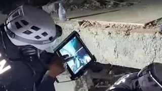 A Jordanian team works to rescue a child trapped under rubble following earthquakes in Venezuela.