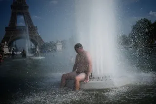 A man cools off at a fountain near the Eiffel Tower during a heatwave in Paris last month. Photo: AP