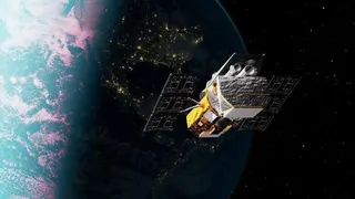 A gold‑coloured space telescope with solar panels and a cylindrical black opening floats in space above the Earth.