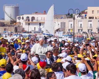 Pope Francis surrounded by a crowd of people in Lampedusa