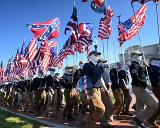 Members of the neo-fascist group Patriot Front march and display the Confederate flag and the US flag