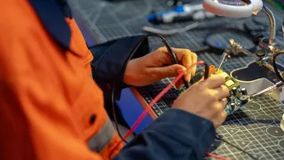 A female worker testing a circuit board in a workshop