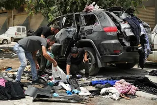 First responders inspect the wreckage of a car reportedly targeted by an Israeli strike in Nabatieh, Lebanon on Monday. Photo: AFP
