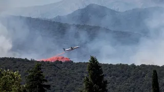 A firefighting plane drops fire retardant as it flies over a wildfire in Ille-sur-Tet near Perpignan in southern France.