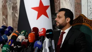 Mohammed Taha al-Ahmed (L), chairman of the Higher Committee for the Syrian People's Assembly Elections, listens during a news conference at the People's Assembly building in Damascus, Syria (1 July 2026)