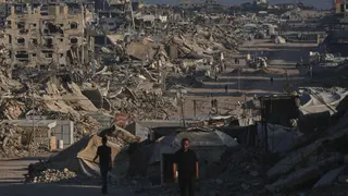 Unos palestinos caminan por una calle rodeada de edificios destruidos por los ataques militares israelíes durante la guerra entre Israel y Hamás, en Jabaliya, en la Franja de Gaza, el jueves 2 de julio de 2026.