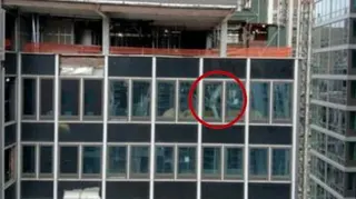 A NYC high-rise building has broken structural beams. In the image, one broken beam is circled in red.