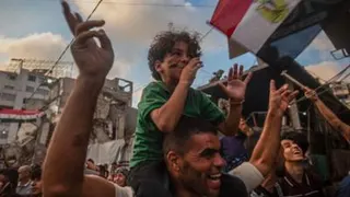 Boy sits on his father's shoulders