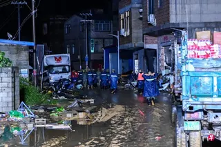 星期二（ 7月7日），在广西南宁横州市校椅镇六蓝村，救援人员徒步赶往受困群众处。 （新华社）