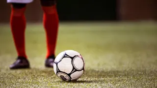 A football player stands behind a ball