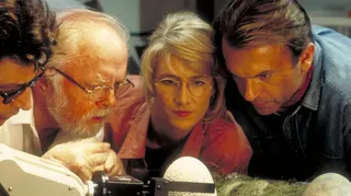 From left to right, actors Jeff Goldblum as Dr. Ian Malcolm, Richard Attenborough as John Hammond, Laura Dern as Dr. Ellie Sattler and Sam Neill as Dr. Alan Grant, watching a robotic arm handle the dinosaur eggs in a scene from the film 'Jurassic Park', 1993.
