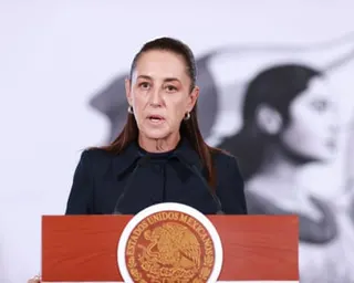 Woman stands at lectern and speaks into microphone