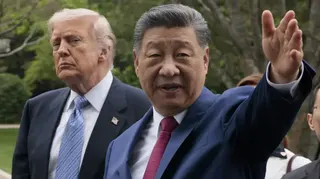 北京中南海花園內習近平（右）給特朗普（左）介紹園景，習近平舉起左手，伸開手掌，指向遠方；特朗普望向右側（15/5/2026）