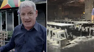A man speaking in front of a building, and on the right the inside of a burned building with tables and chairs.
