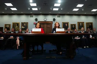 Supreme Court Justices Elena Kagan and Amy Coney Barrett sit at a testimony table in a formal hearing room