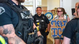 Protesters outside Susan Collins office, seen next to police.