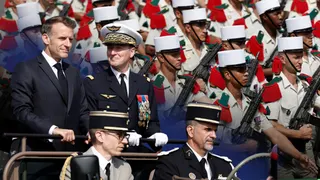 French President Emmanuel Macron stands in the command car with General Chief of Staff of the French Armed Forces Fabien Mandon during the annual Bastille Day military parade on the Champs-Elysees avenue in Paris, France, July 14, 2026.