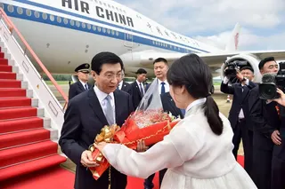 Wang Huning, a standing committee member of the Communist Party of China Politburo, receives flowers upon his arrival at Pyongyang International Airport on July 15.