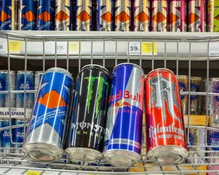Four canned energy drinks in shopping basket in Tesco