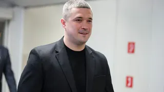 Mykhailo Fedorov - a man wearing a grey jacket and black top, with close-cropped grey hair