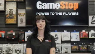 A woman stands behind the counter at GameStop.