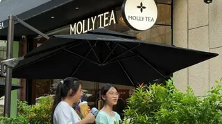 茉莉奶白商標，下面是傘下兩人