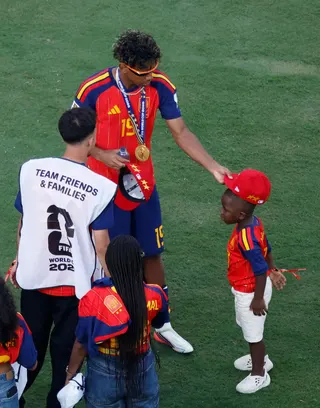 Lamine Yamal puts a cap on his younger brothers head following his World Cup win