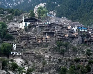 Dozens of homes of varying sizes cling precariously to a mountainside