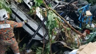 一辆罗里与长途巴士在南北大道相撞后，罗里失控坠落约8公尺深山谷，消拯员赶抵现场展开救援。（图由消拯局提供）