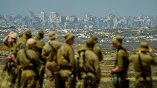 Israeli soldiers looking at the destroyed Jabalia area, in the northern Gaza Strip, from near Kibbutz Nir Am, Israel (22 April 2026)