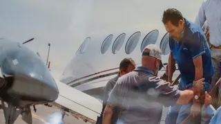 Zambada, in a blue golf shirt, is helped off a small plane while being taken into custody in July 2024