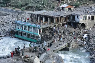 Residents and rescue workers inspect buildings damaged by heavy flooding in the eastern province of Nuristan, Afghanistan, Tuesday, July 21, 2026. (AP Photo/Wahidullah Kakar)