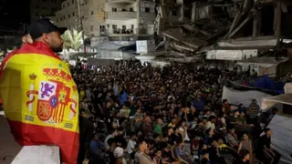 A large crowd in Ramallah watches an outdoor event at night, with officials seated in front rows