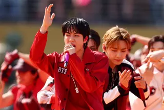 身穿黑红和白红配色服装的韩国人气男团BTS演唱热单“Dynamite”，引发全场狂欢。（路透社）