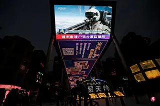 台湾军方星期一（7月20日）侦获四架次解放军直升机与无人机越过台海中线，其中一架直升机与一架无人机首次沿着台湾军方划设的限航区长时间飞行。图为2023年8月19日，北京街头大屏幕播放着解放军东部战区空军飞机在台湾附近参加军事演习的新闻画面。 （路透社档案照片）