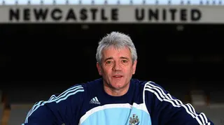 Kevin Keegan posing for a photo inside St James' Park, with the Newcastle United lettering on the East Stand behind him