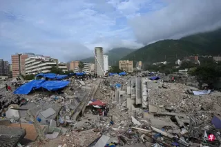 7月23日，在委内瑞拉卡拉瓦列达，志愿者和救援队仍在搜寻损毁建筑物底下的遇难者遗体。 （法新社）