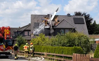 The tail of a light aircraft protrudes from the roof of a house after a crash in Ganderkesee, Germany, on July 25, 2026. Two men were killed after the plane crashed into the residential building. — AFP pic