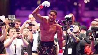 Anthony Joshua celebrates in the ring in front of photographers