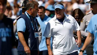 Michael Lombardi talks with Bill Belichick before a game at Kenan Memorial Stadium.