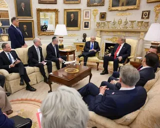 men in suits sit in a room