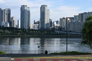 6月24日，一名男子坐在首尔汉江边。（图取自法新社）