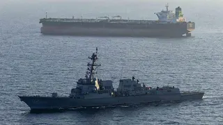 A US military ship is seen in the foreground in the Arabian Sea in April, while another ship is seen in the background.