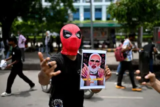 A CJP supporter holds a poster showing an altered image of Prime Minister Narendra Modi in New Delhi on July 25. Photo: AFP